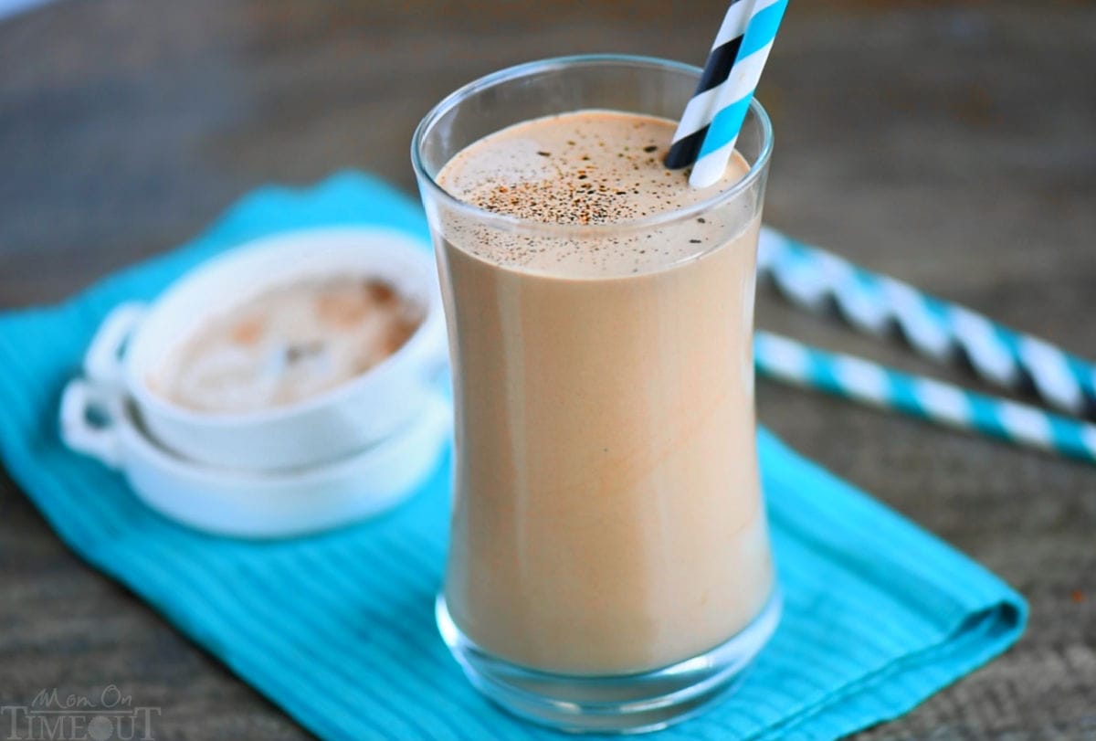 Wide shot of protein shake with coffee sitting on a teal napkin with two small white bowls in the background.