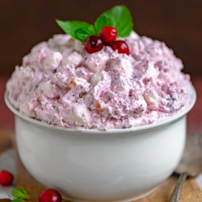 Cranberry Fluff recipe served in white bowl and topped with fresh cranberries and mint.