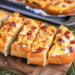 Wide shot of a half loaf of cheese bread cut into slices and ready to serve.