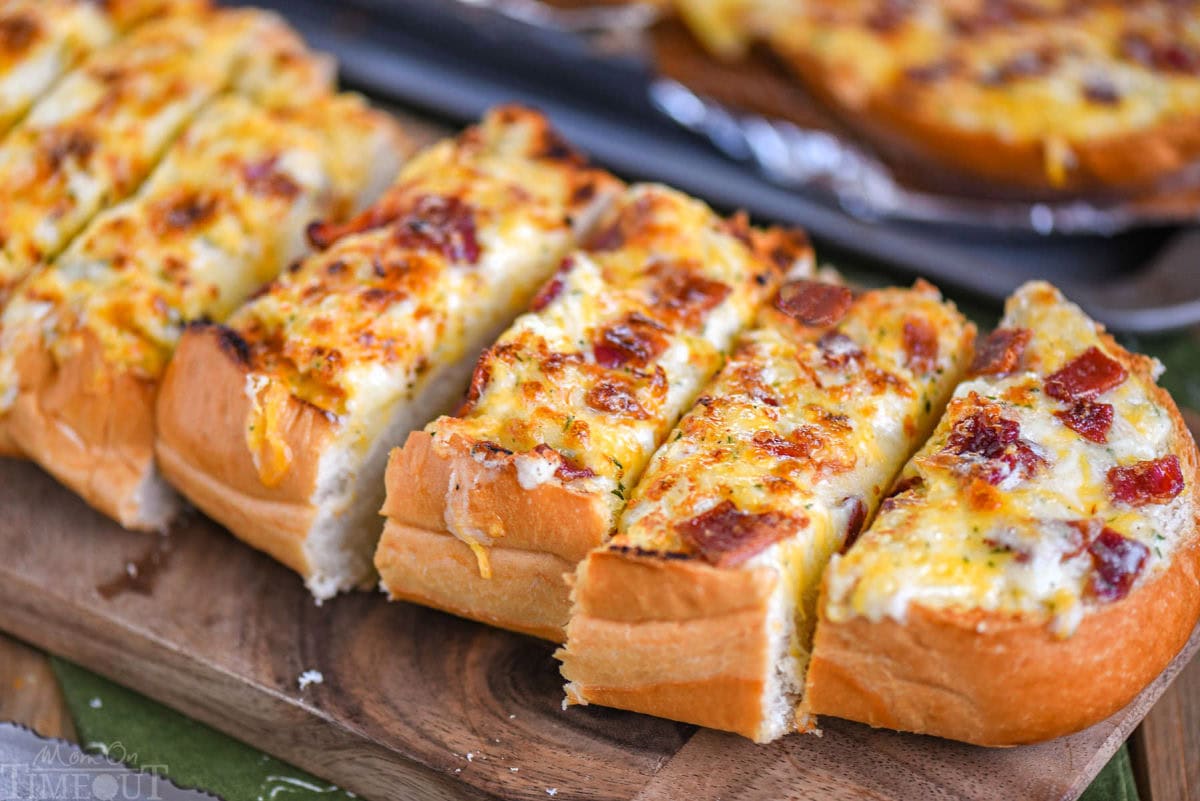 Wide shot of a half loaf of cheese bread cut into slices and ready to serve.