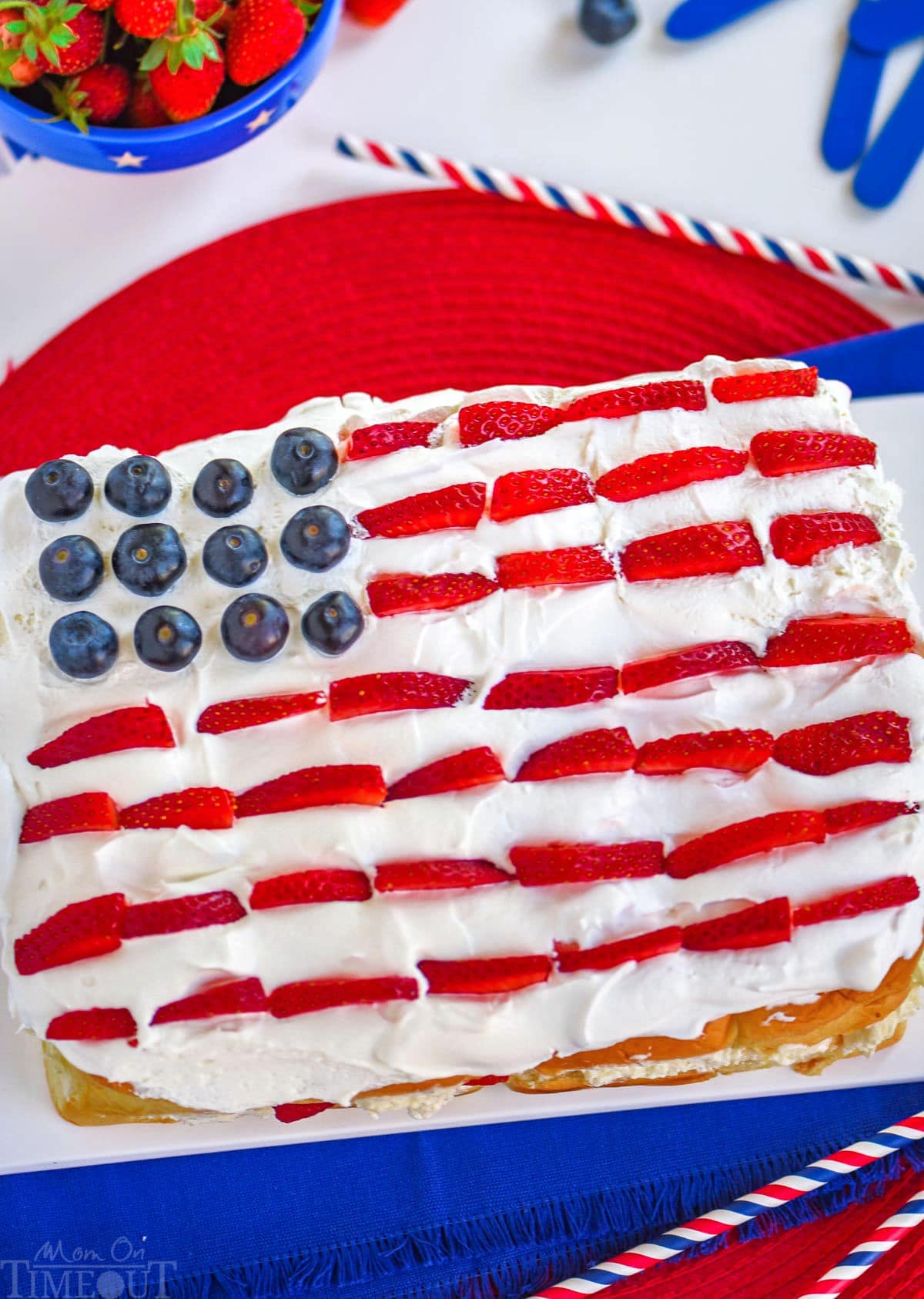 Top down view of a flag decorated dessert for the 4th of July made with hawaiian rolls, berries and no bake cheesecake.