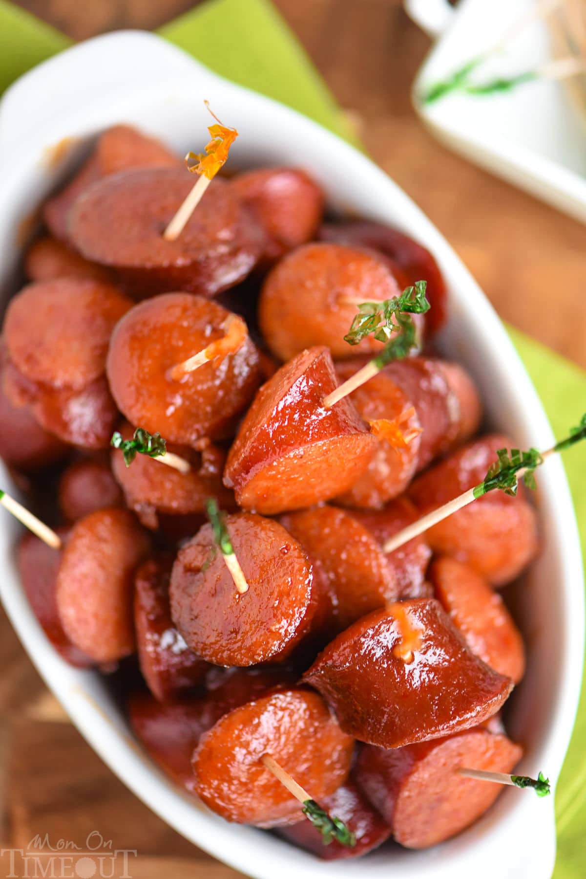 Top down look at white slow cooker full of kielbasa in a sauce made of chili sauce, bbq sauce and grape jelly.