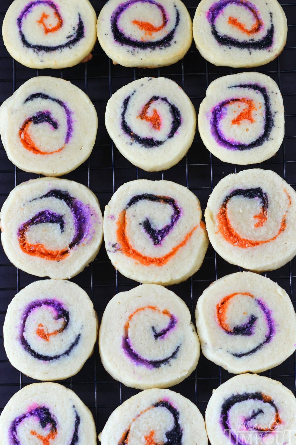 Top down look at spiral slice and bake halloween cookies on a black wire rack.