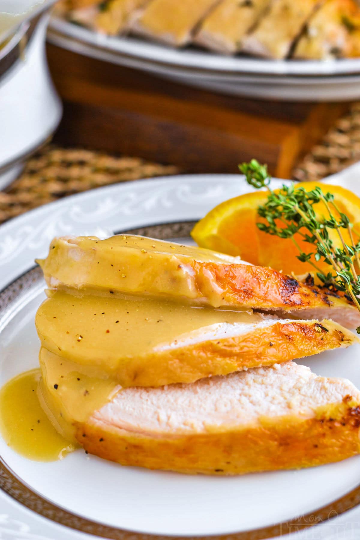 Crockpot turkey breast sliced and plated with turkey gravy on top.