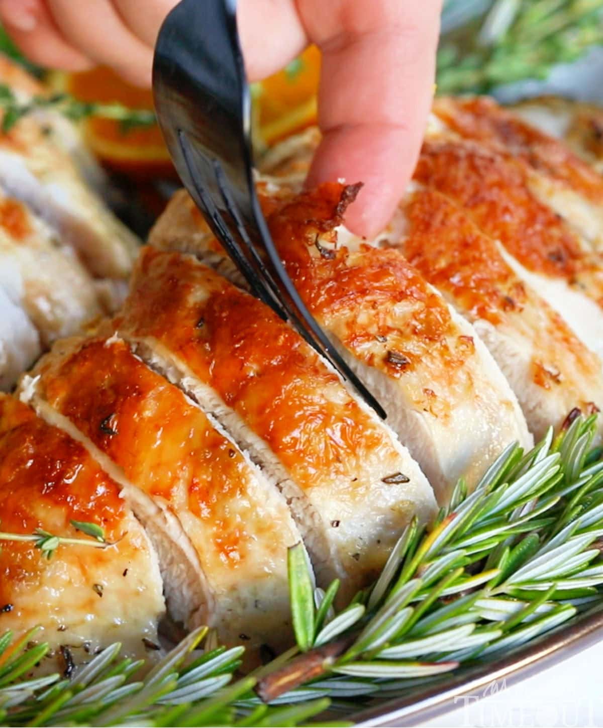 Turkey breast made in slow cooker with crispy skin sliced and being served.