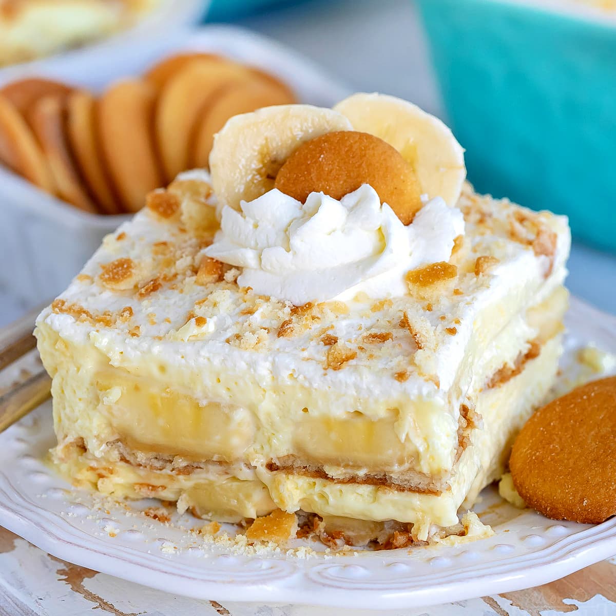 The Best Banana Pudding Recipe Served On A White Plate Garnished With Whipped Cream And Nilla Wafers Square Image 