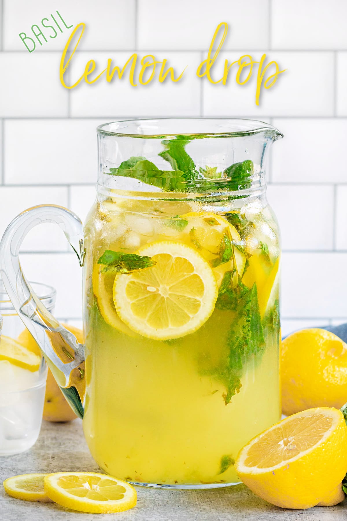 https://www.momontimeout.com/wp-content/uploads/2020/08/basil-lemon-drop-in-glass-pitcher-with-lemon-slices-in-and-around-pitcher-with-title-overlay.jpg