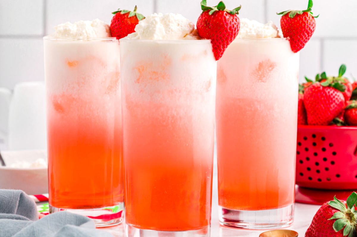 line up of 3 italian sodas garnished with fresh strawberries.