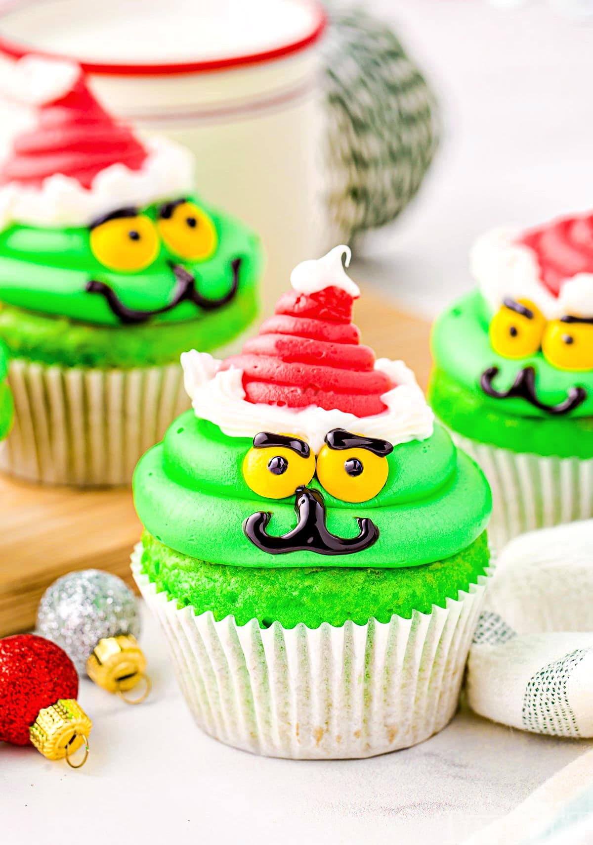 https://www.momontimeout.com/wp-content/uploads/2022/12/christmas-cupcakes-decorated-like-the-grinch.jpeg