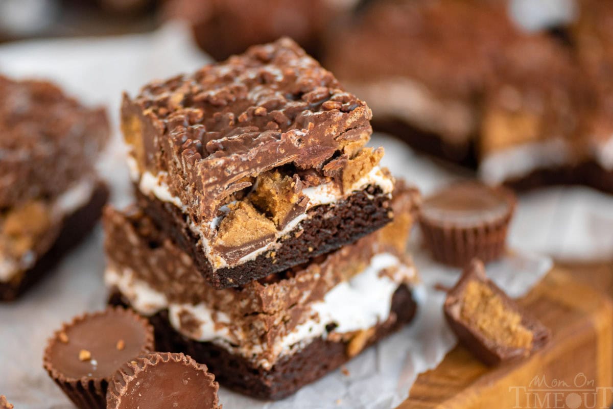 A stack of two Reese's Marshmallow Brownies which reese's peanut butter cups scattered around.