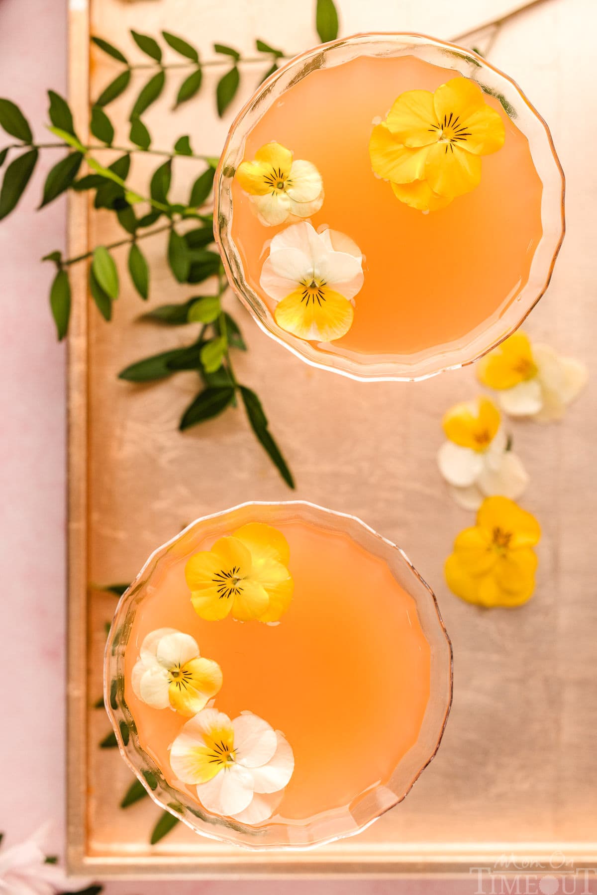 A Top down shot of french blonde cocktails in glasses on a metal tray.