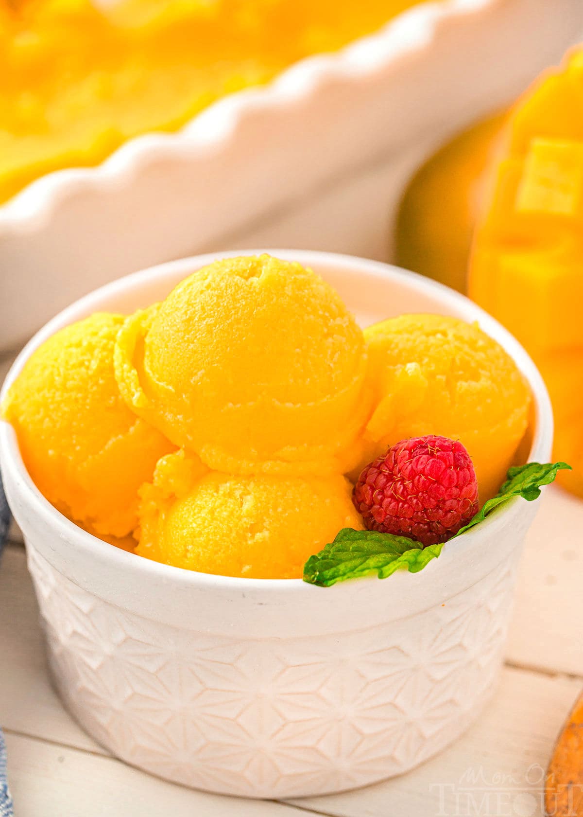 Scoops of mango sorbet in a white bowl.