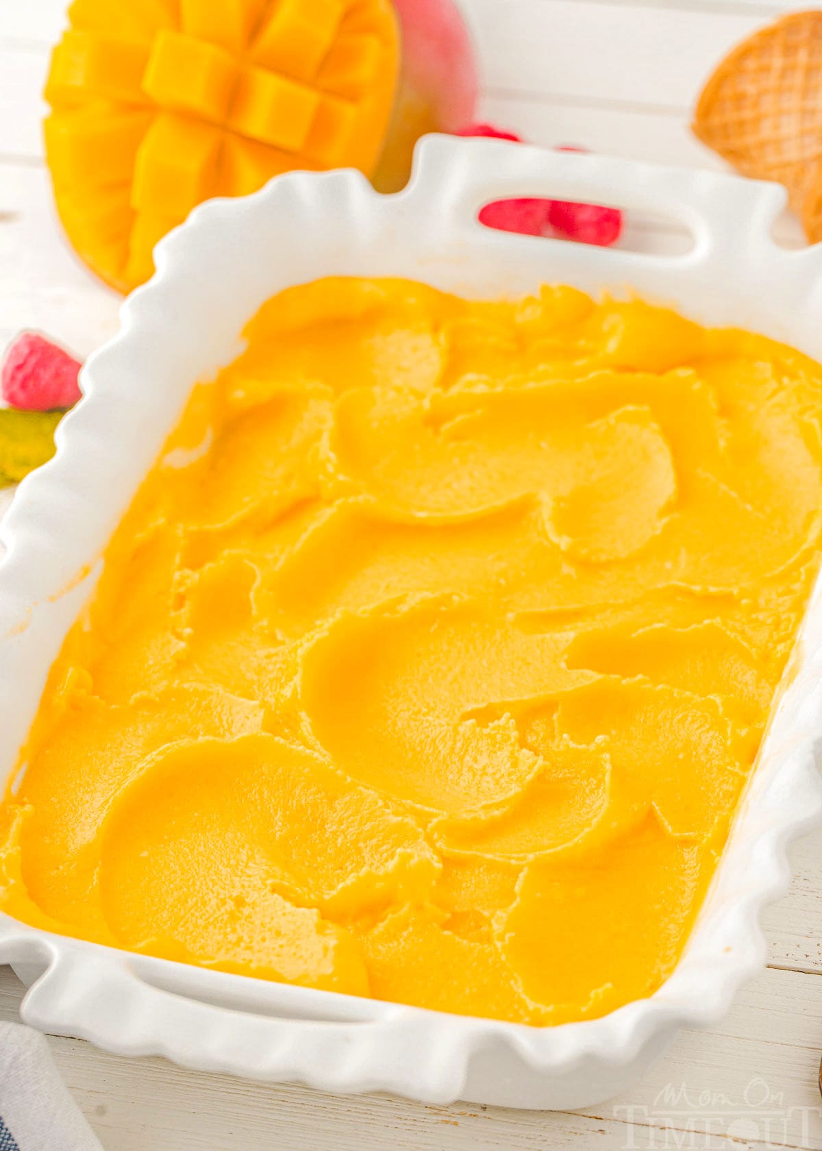 Top down view of mango sorbet in a white pan.