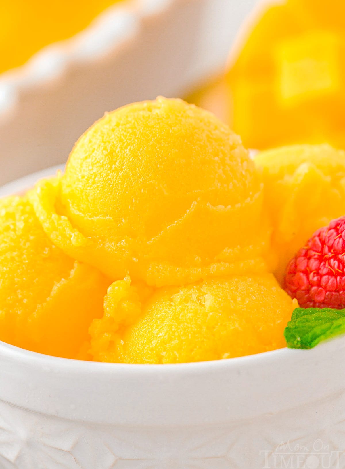 Scoops of mango sorbet in a white bowl.