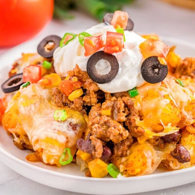 A piece of mexican tater tot casserole on a white plate.