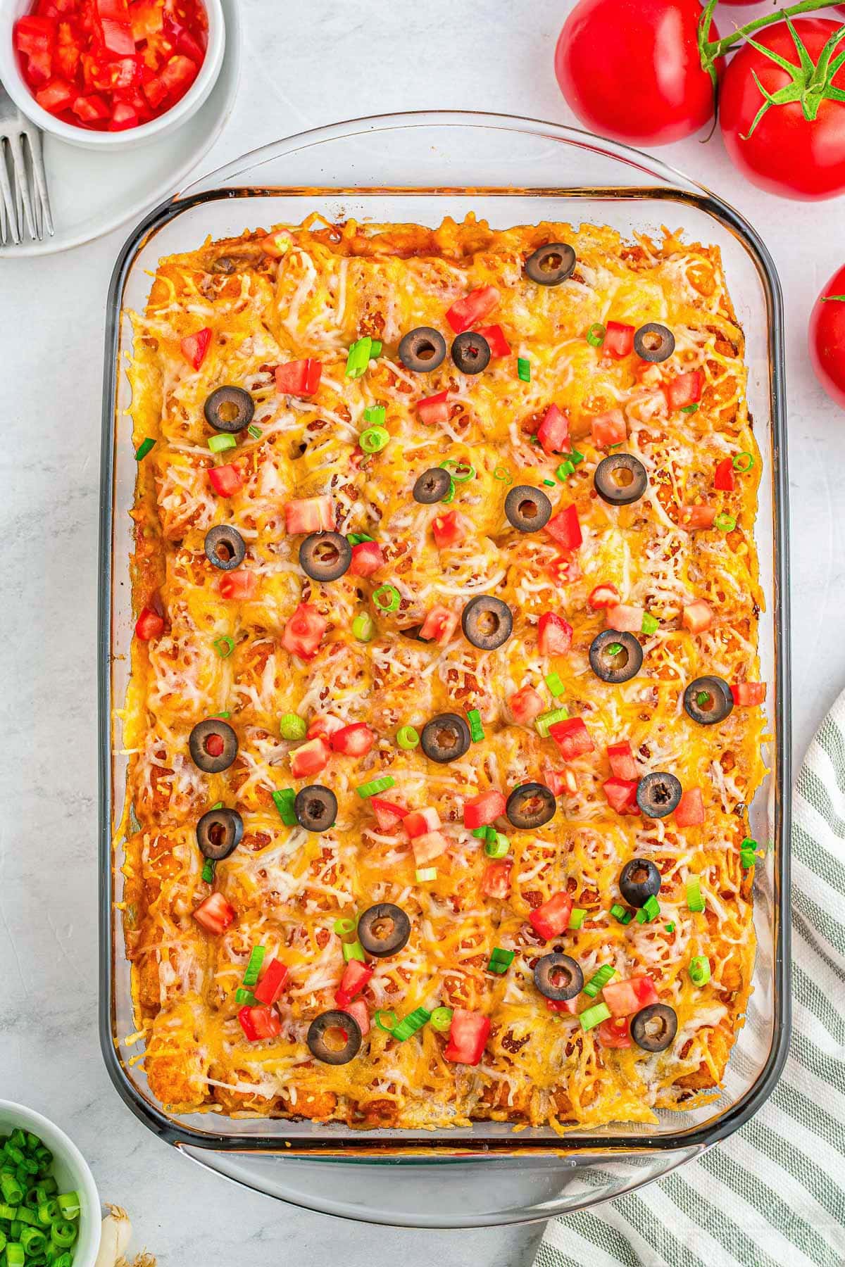 A top down view of mexican tater tot casserole in a glass pan.