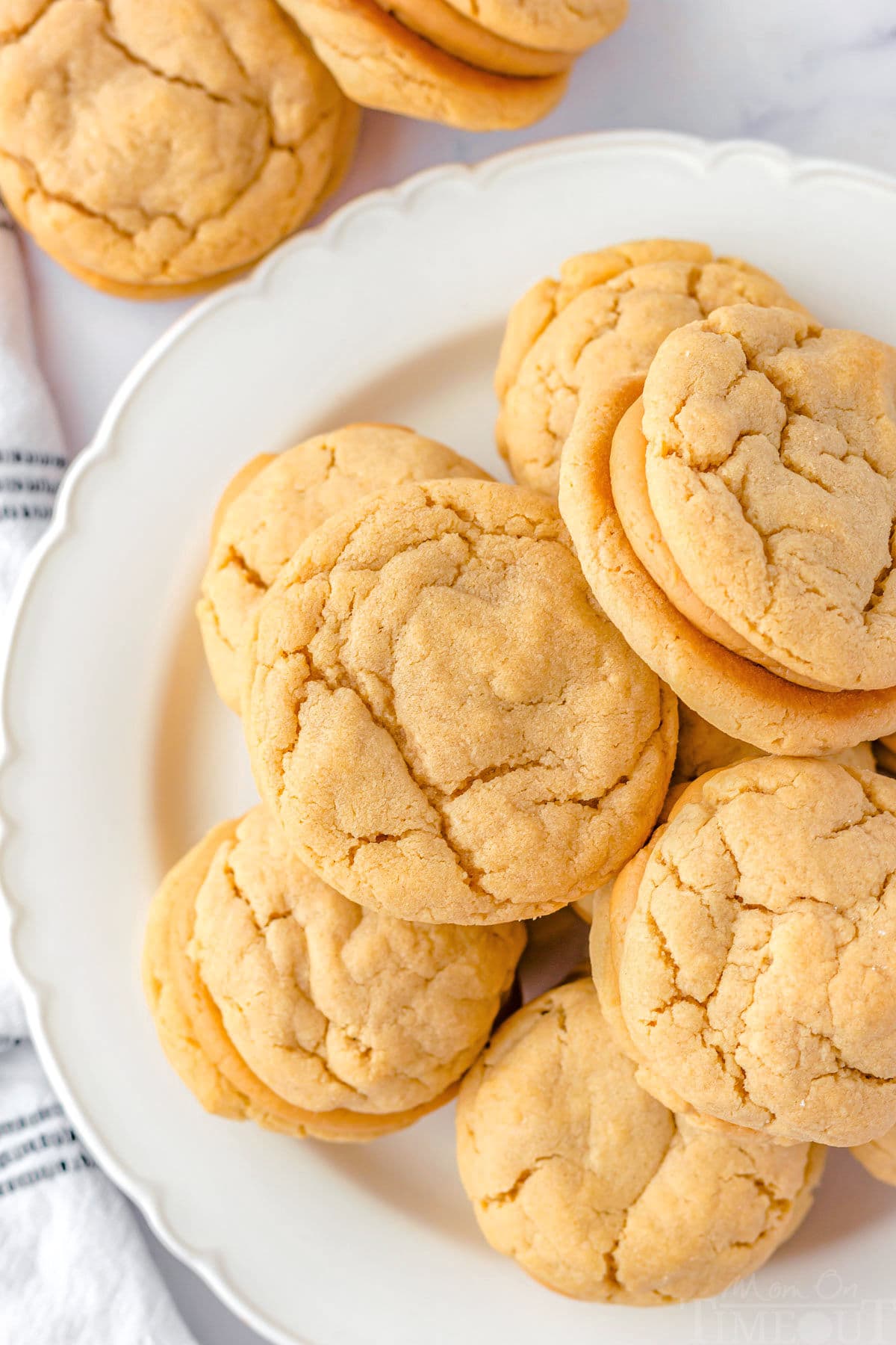 Top down view of peanut butter stuffed cookies on a white round plate.