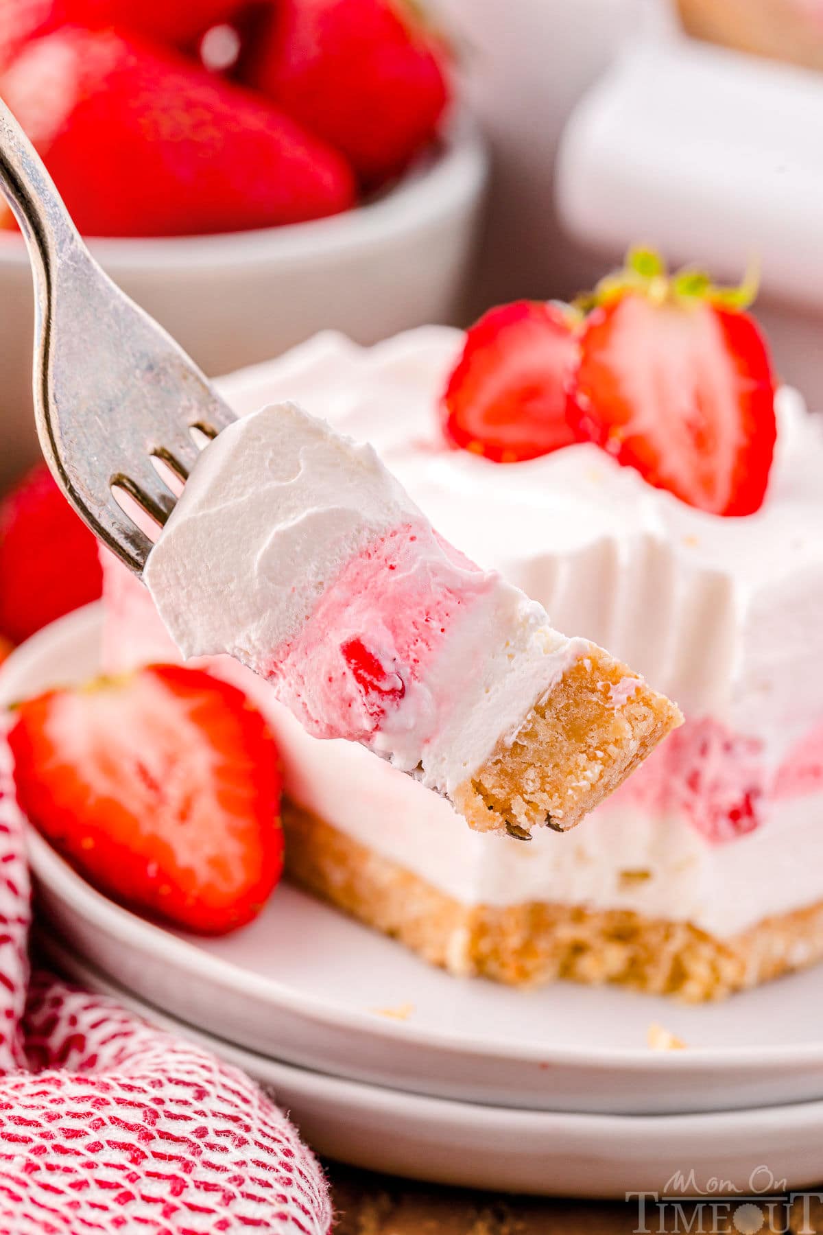 A fork with a bite of strawberry lasagna on it.