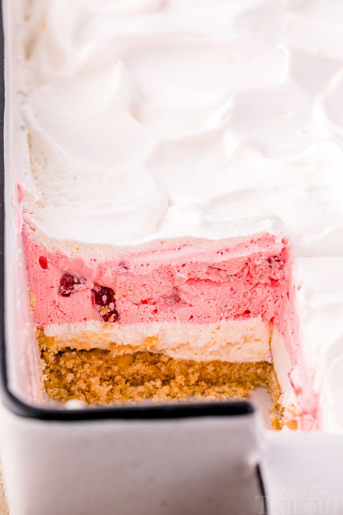 Strawberry lasagna with a slice taken out of it.