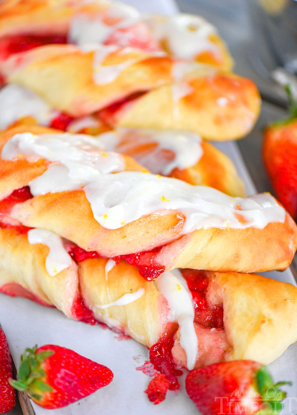 Two strawberry twists stacked on top each other with strawberries placed next to it.