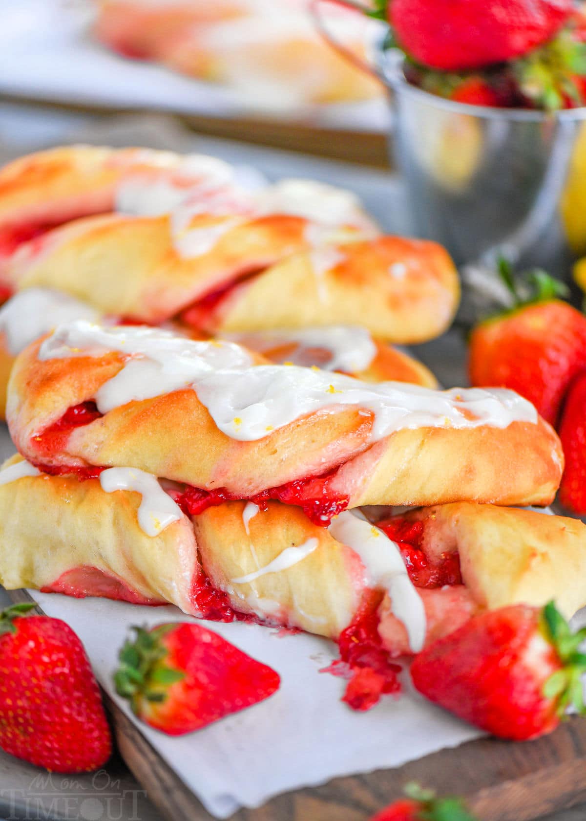 A side shot of Strawberry Twists with strawberries in front of them.