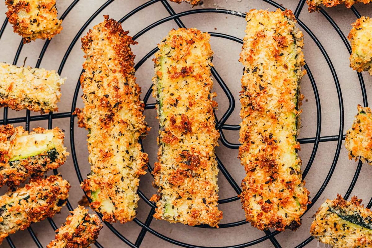 Air Fryer Zucchini Fries cooling on a black wire rack.