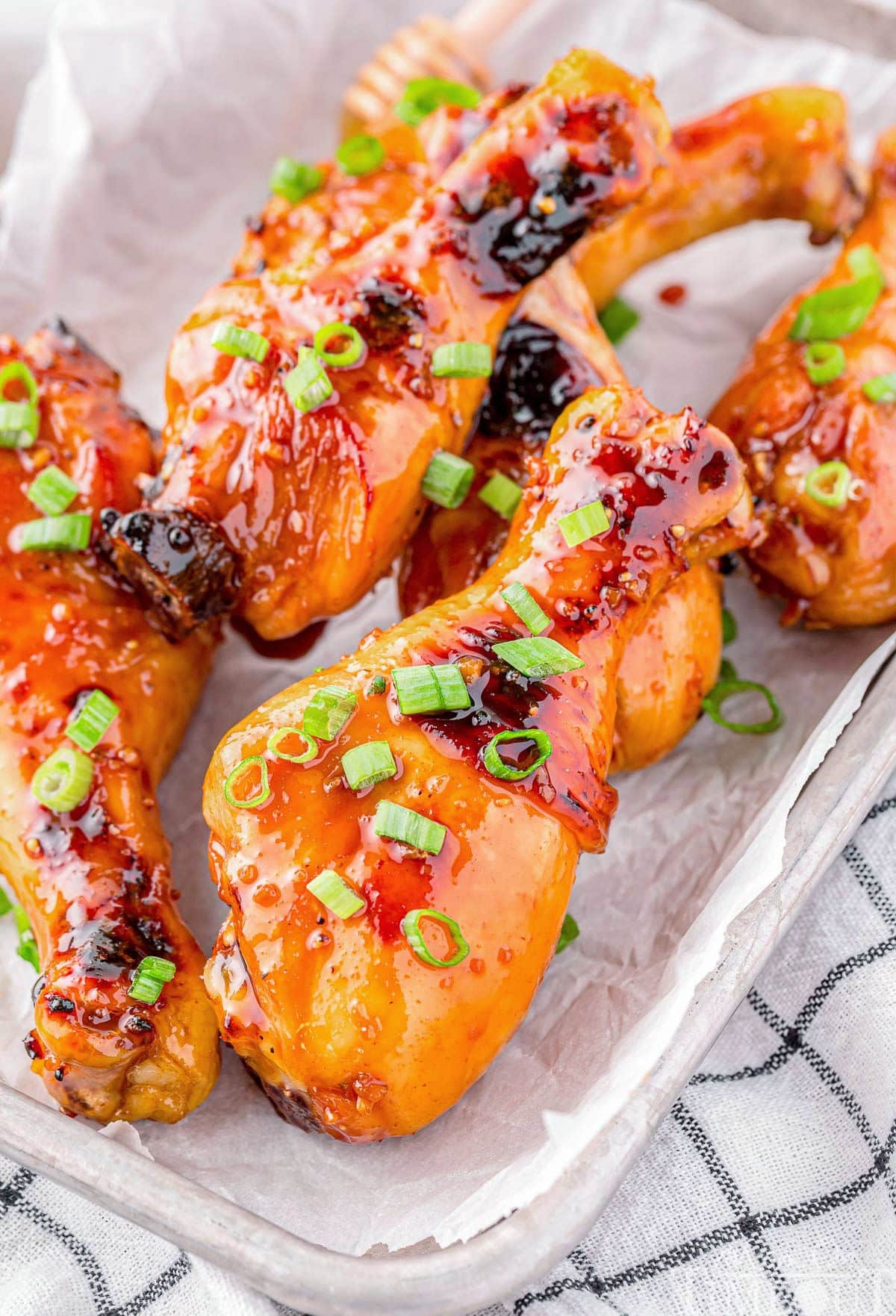 Honey Glazed Chicken drumsticks laying on a tray.