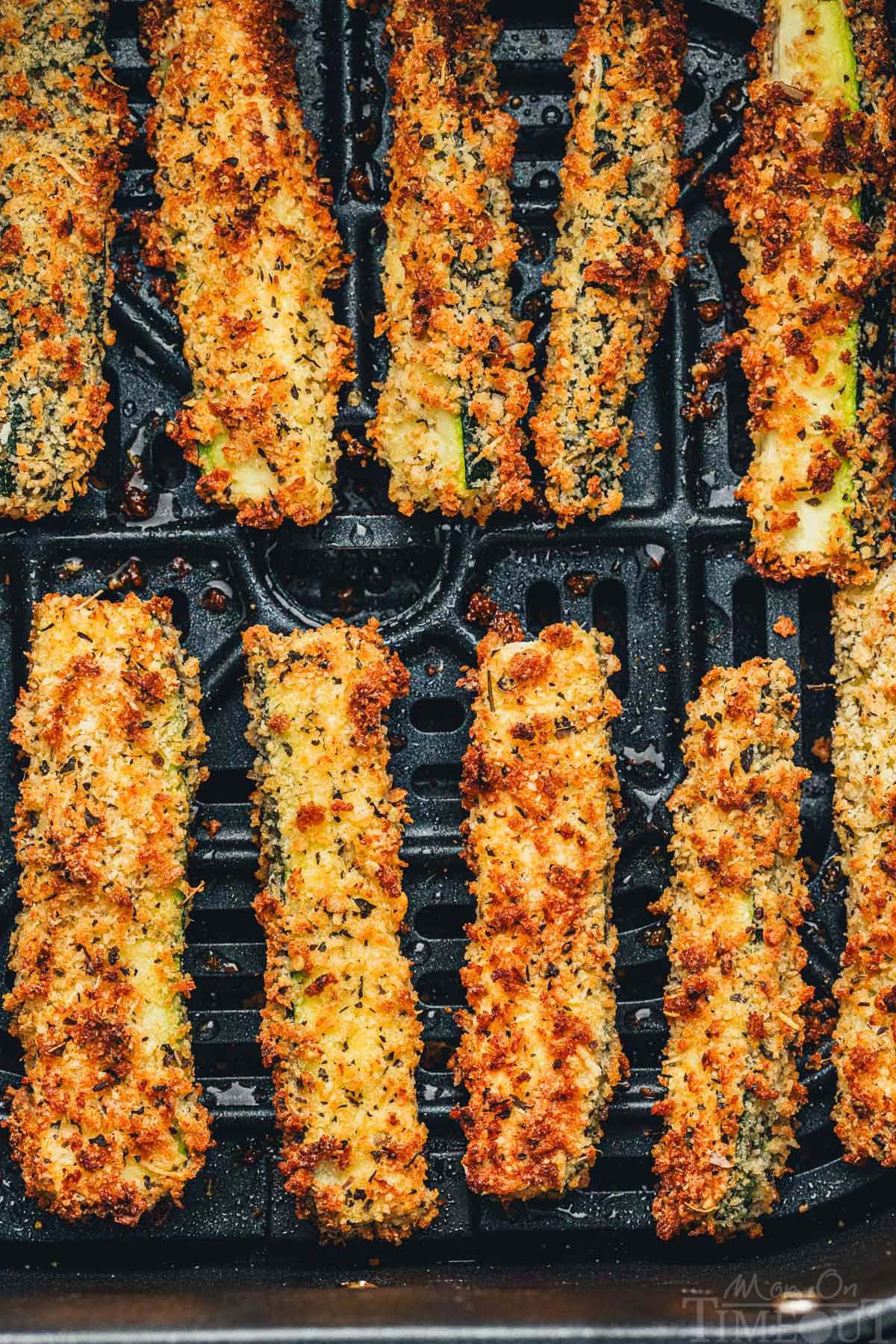 Top down view of zucchini fries cooked in an air fryer.