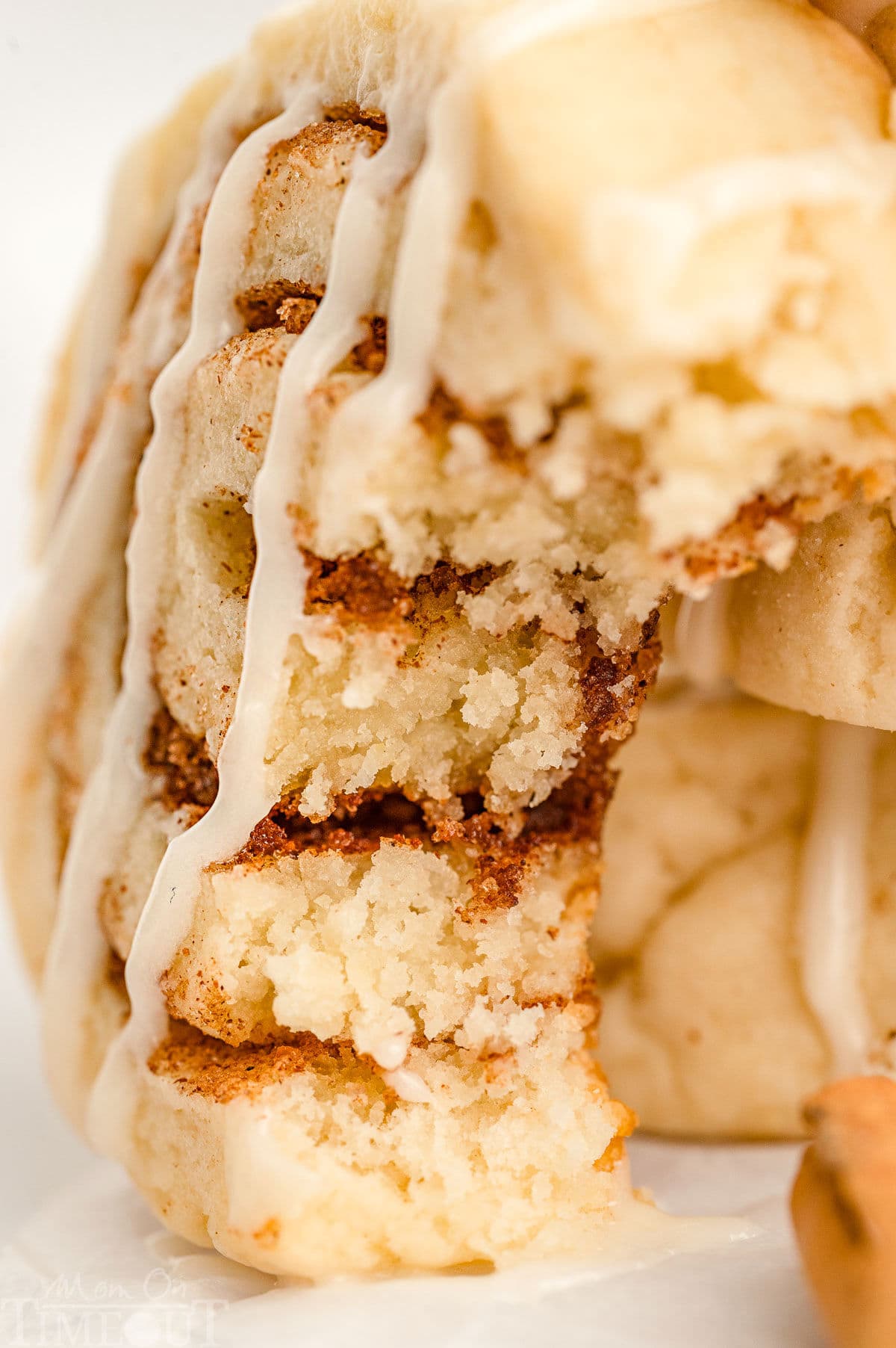 A close up shot of a cinnamon roll cookie with a bite take out of it.