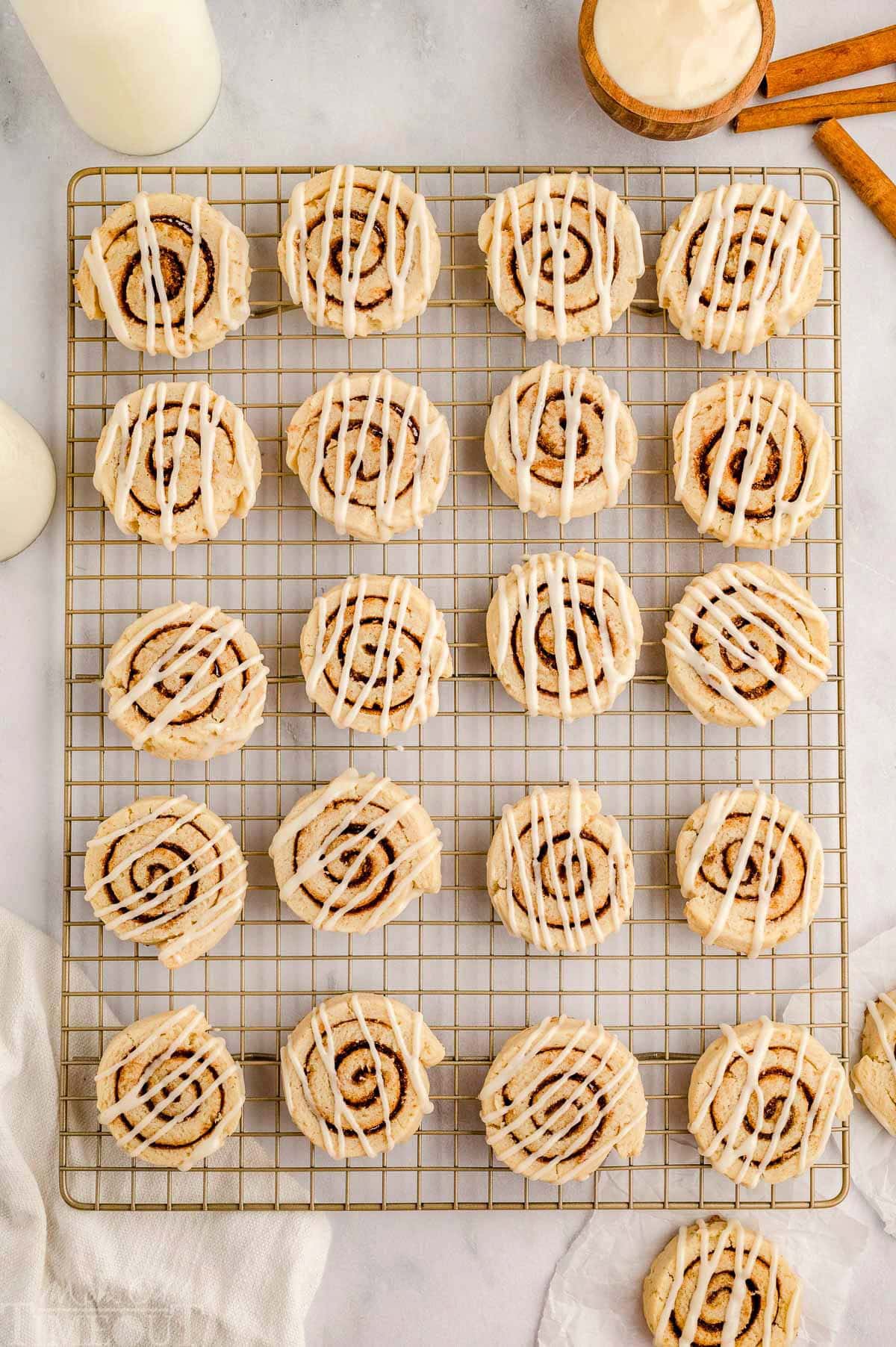 Top down view of cinnamon roll cookies recipe on wire rack drizzled with cream cheese icing. 