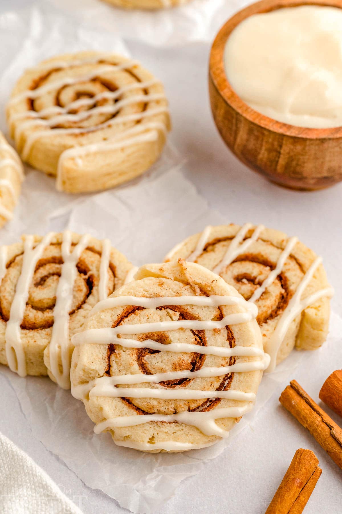 Cinnamon roll cookies laying on a piece of parchment paper.