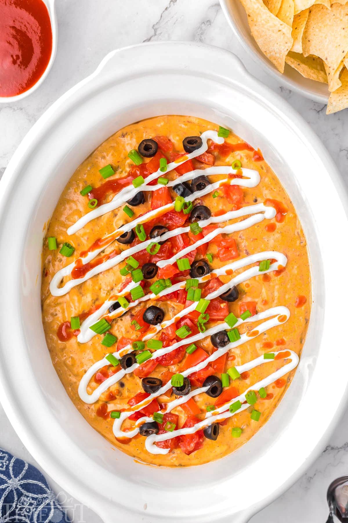 Top down view of crockpot taco dip in a white crockpot liner.