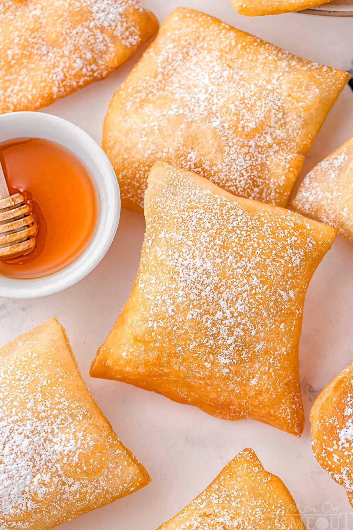 A top down shot of sopapillas on a white surface.