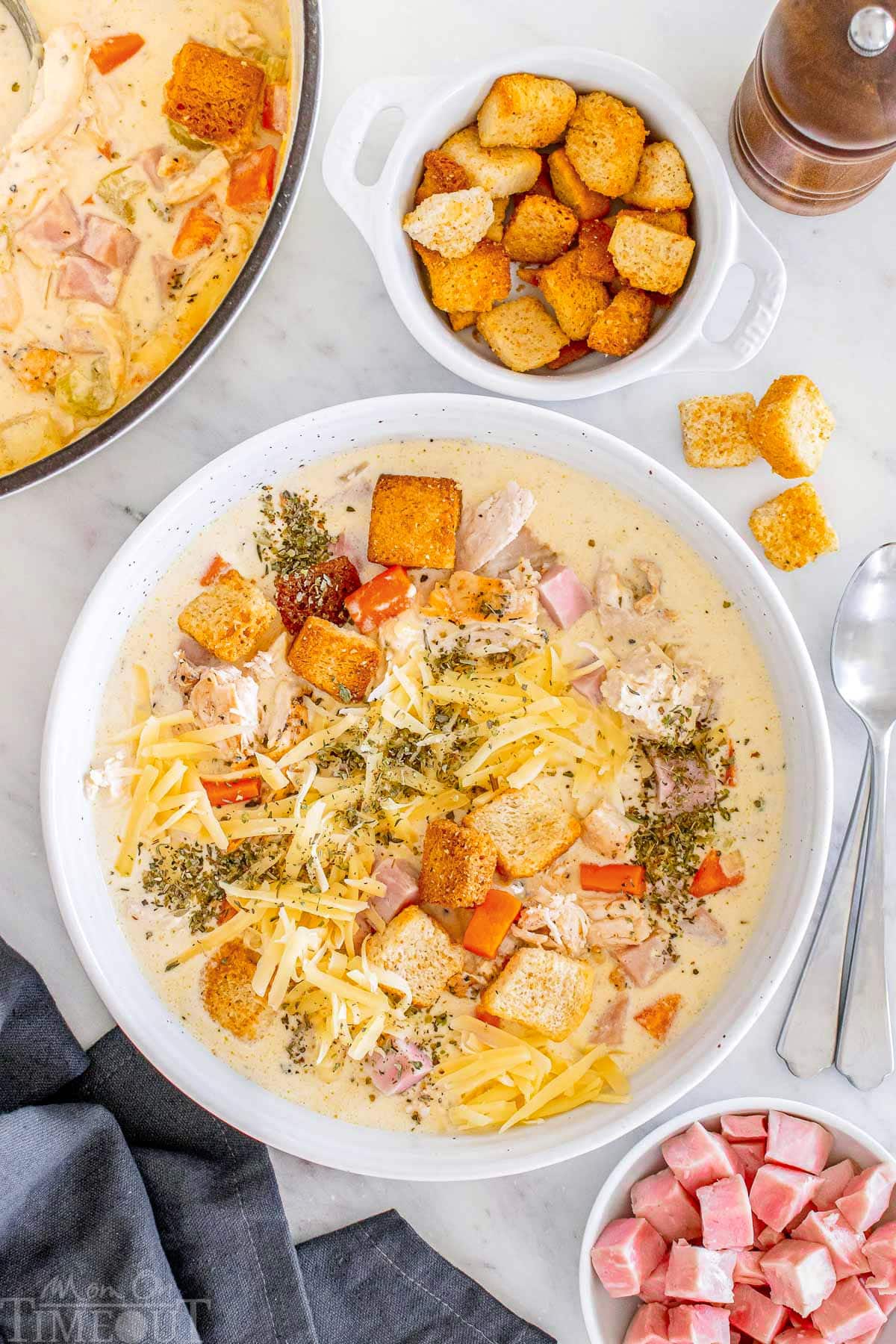 A top down shot of chicken cordon bleu soup in a white bowl.