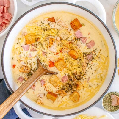 Chicken cordon bleu soup in a dutch oven with wood spoon.