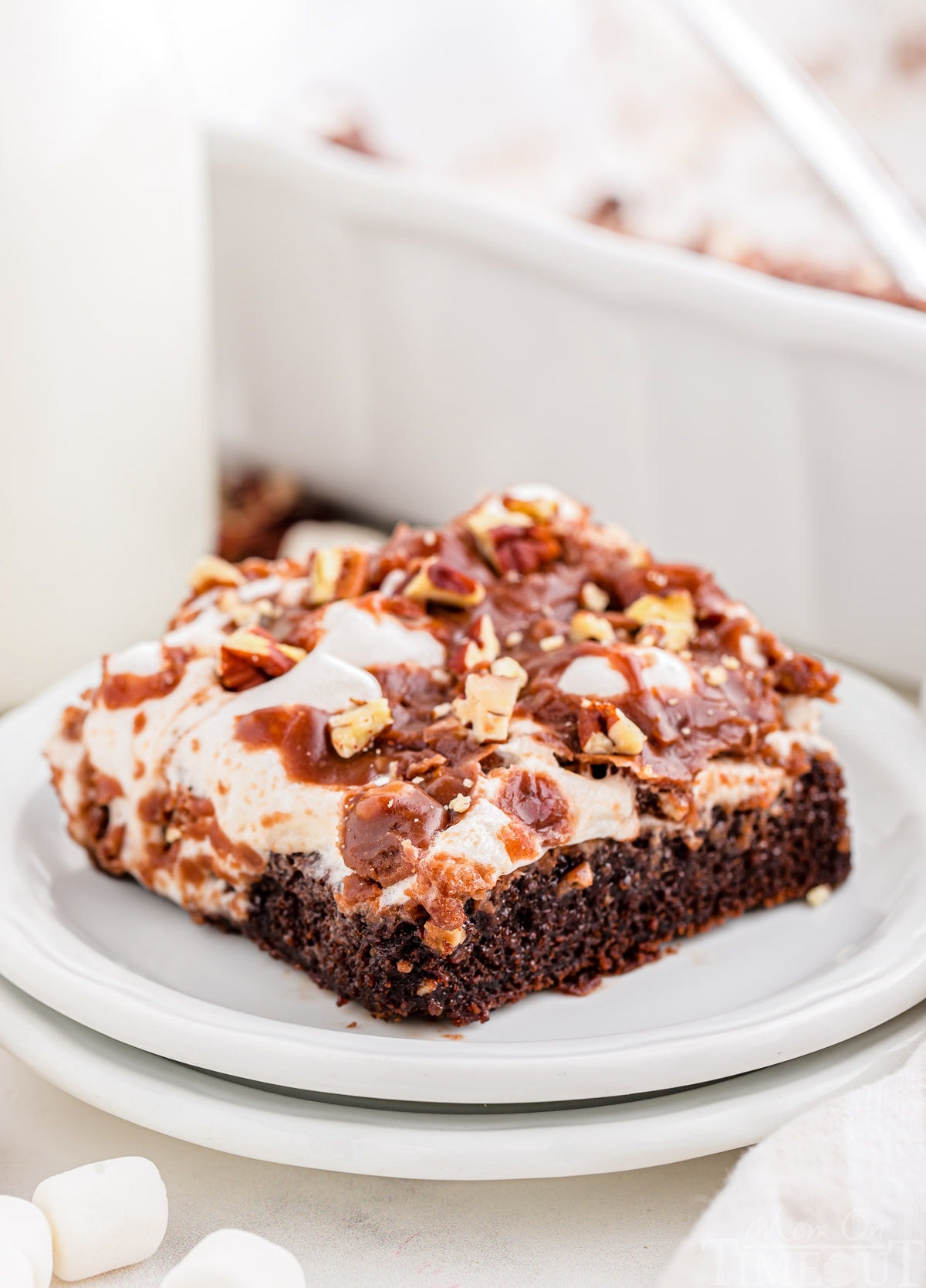 Piece of Mississippi Mud Cake on a round white dessert plate stacked on another plate.