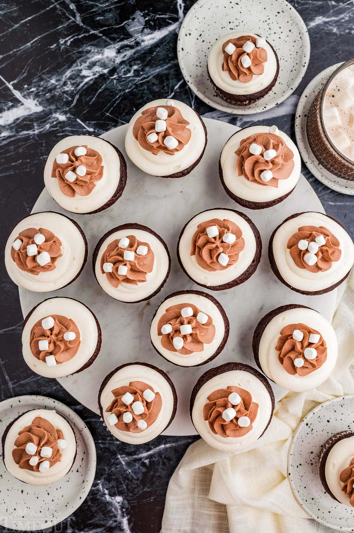 A top down shot of hot chocolate cupcakes on a round marble serving tray.