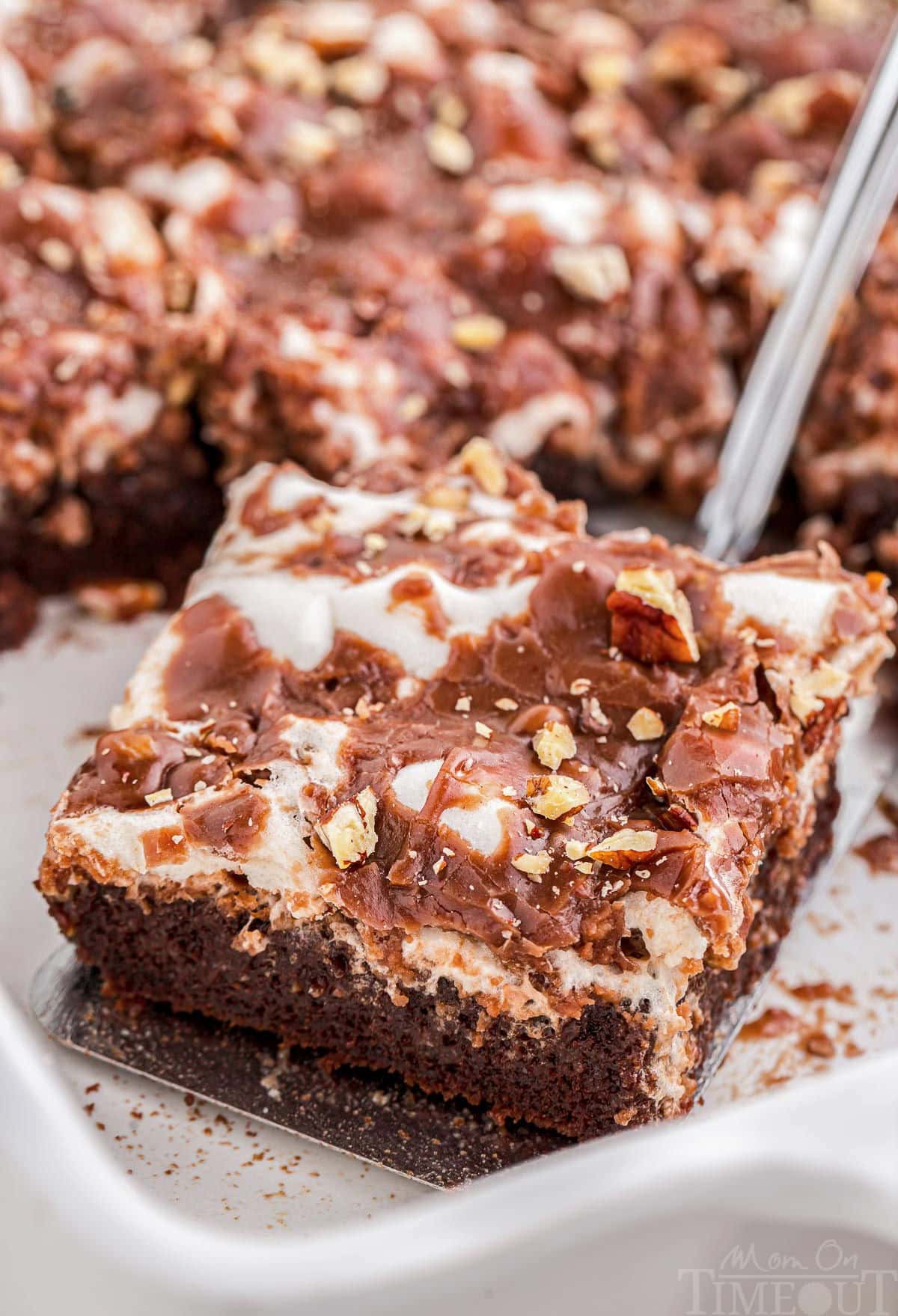 Piece of Mississippi Mud Cake being served from a white baking pan.