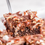 Slice of Mississippi Mud Cake being lifted away from the rest of the cake with a server.