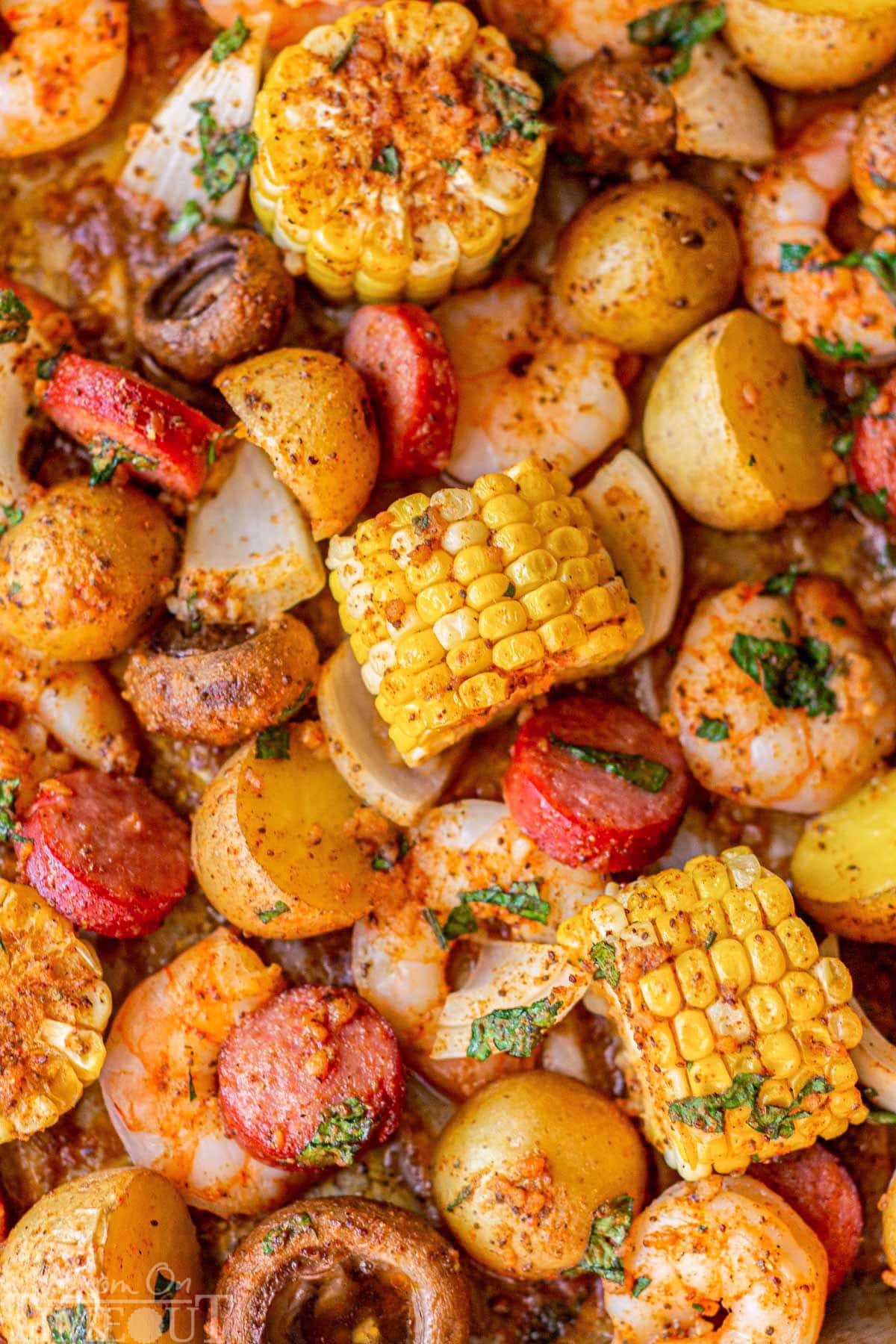 Top down view of sheet pan low country shrimp boil topped with parsley.