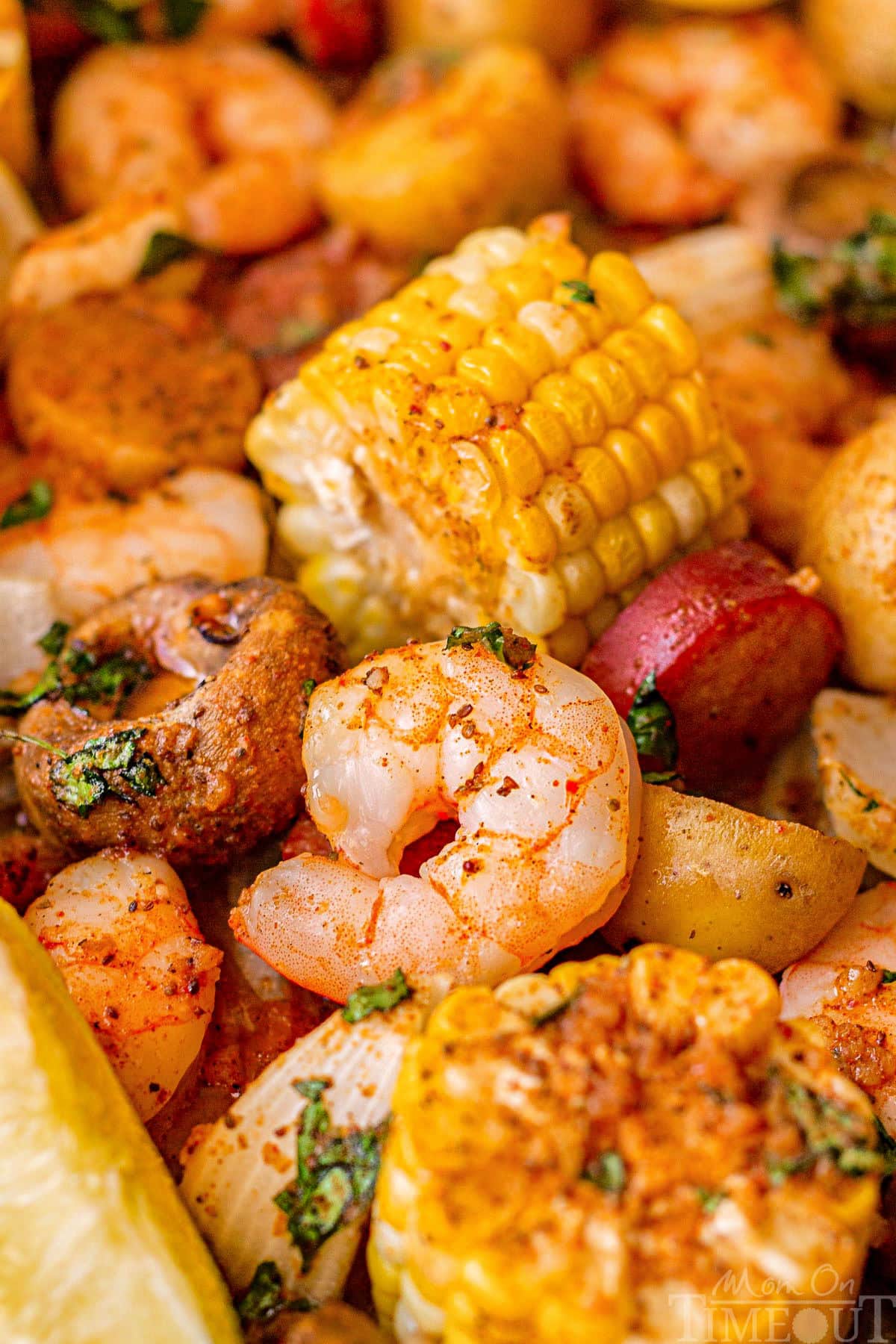 Close up of shrimp boil on a sheet pan. Corn, shrimp, sausage and potatoes.