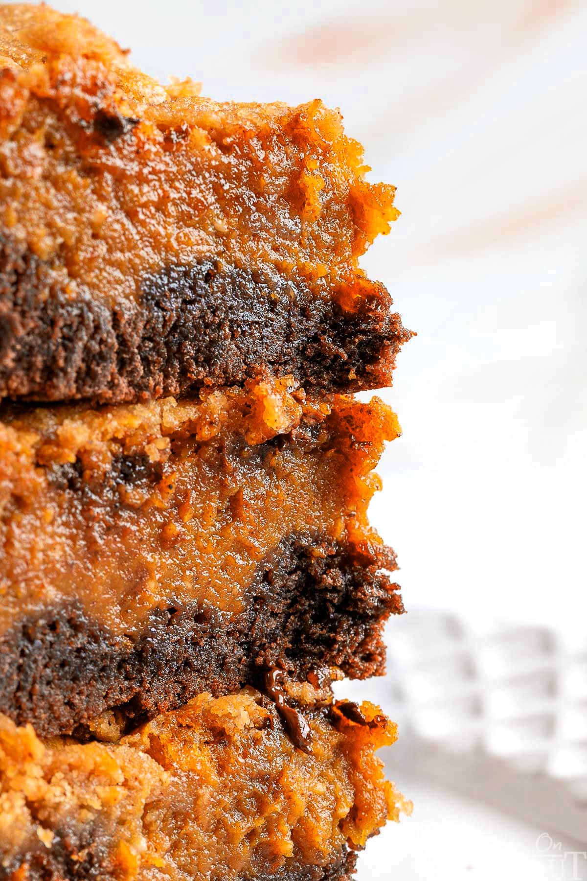 A close up photo of a stack of chocolate pumpkin bars on a white plate.