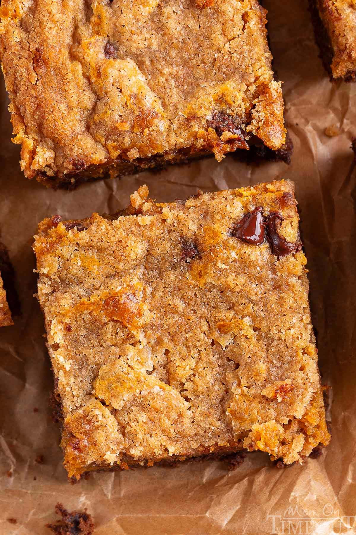 A top down view of chocolate pumpkin bars on a piece of brown parchment paper.