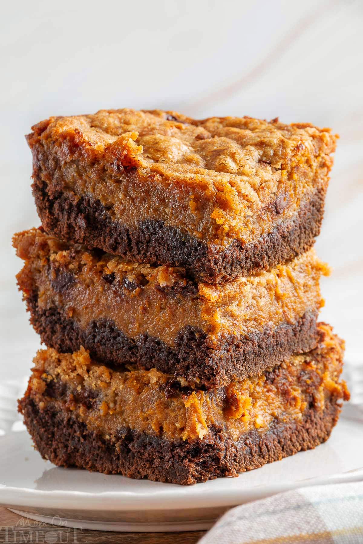 A stack of chocolate pumpkin bars on a white plate.