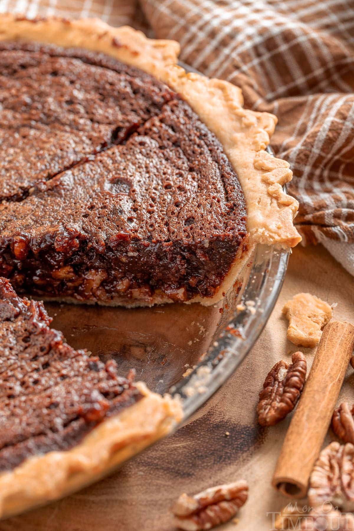 Angled view looking down on a chocolate pecan bourbon pie with a slice removed.