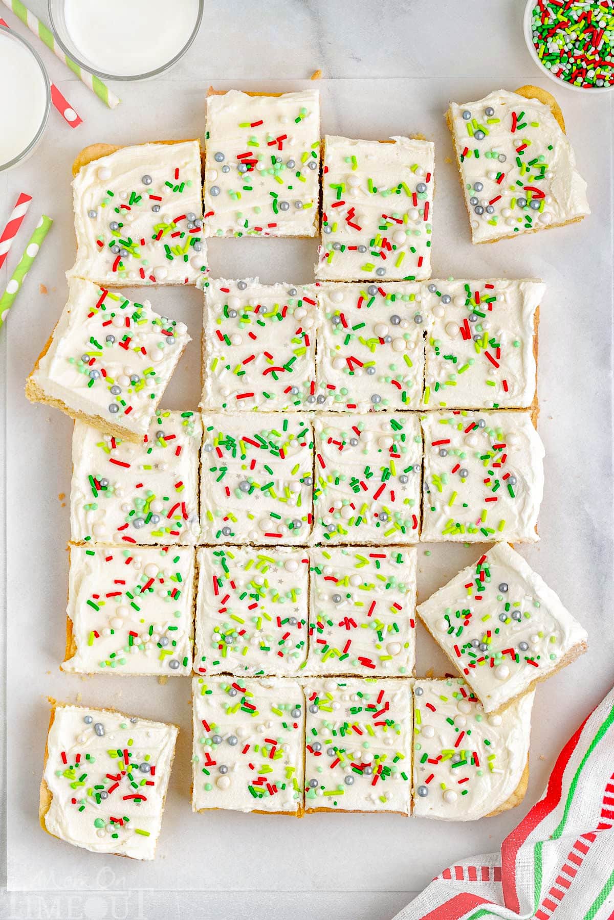 A top down shot of the sugar cookie bars cut into squares on a piece of parchment paper.