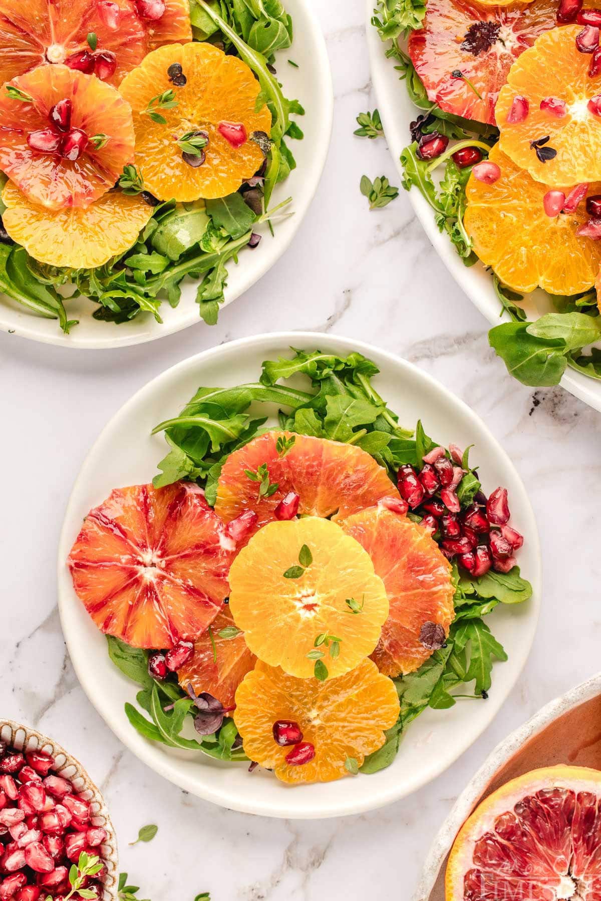 Two small white round plates topped with citrus salad recipe. 