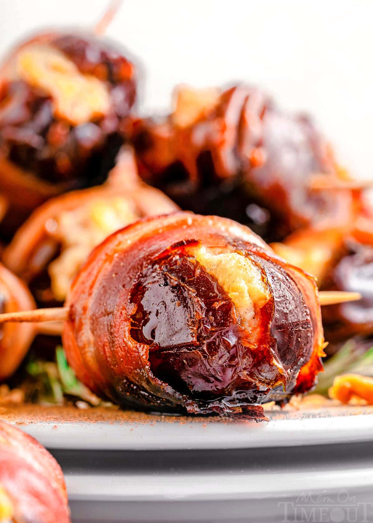 Bacon wrapped dates on white plate ready to be served.