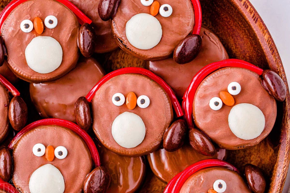 Top down look at a dozen penguins made with oreo cookies on a wood tray.