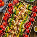 Top down view of antipasto skewers on a sheet pan drizzled with balsamic glaze and ready to eat.